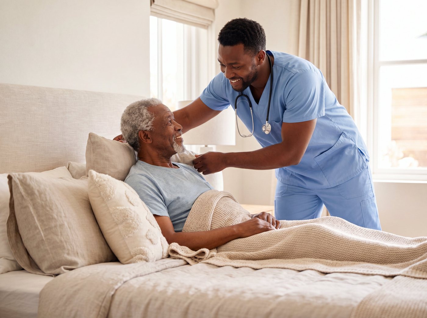 A home-care nurse warmly attending to an older man resting in bed